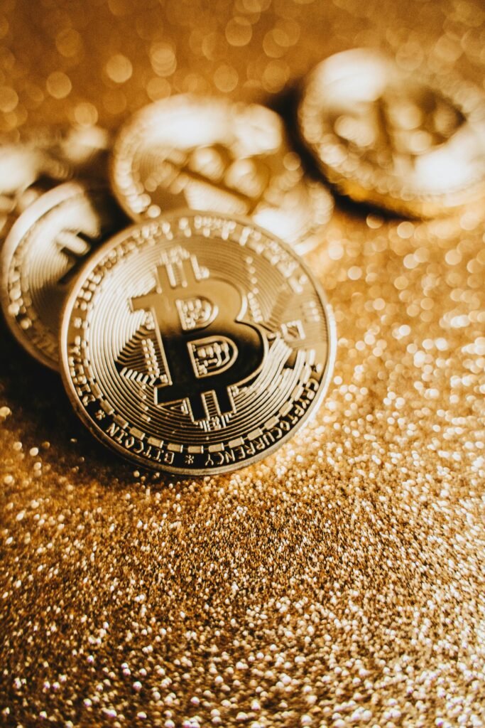 Close-up of Bitcoin coins on a glittering gold background representing cryptocurrency and finance.